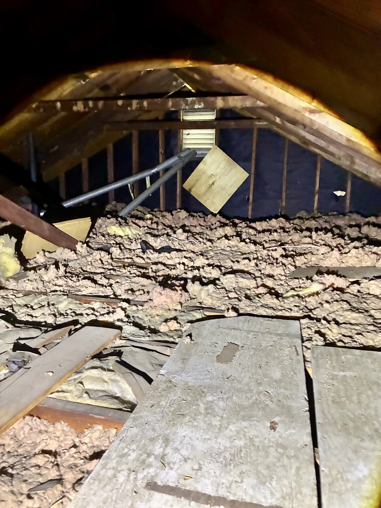 Older uneven attic insulation before removal and replacement in a Hampton Roads home