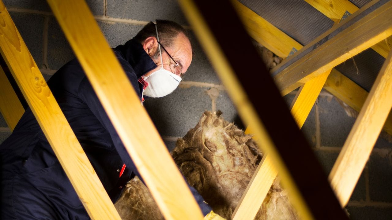 a contractor insulating an old attic home