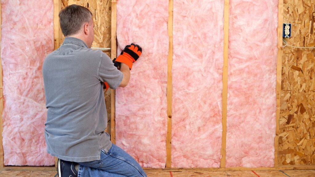 professional installing fiber glass insulation